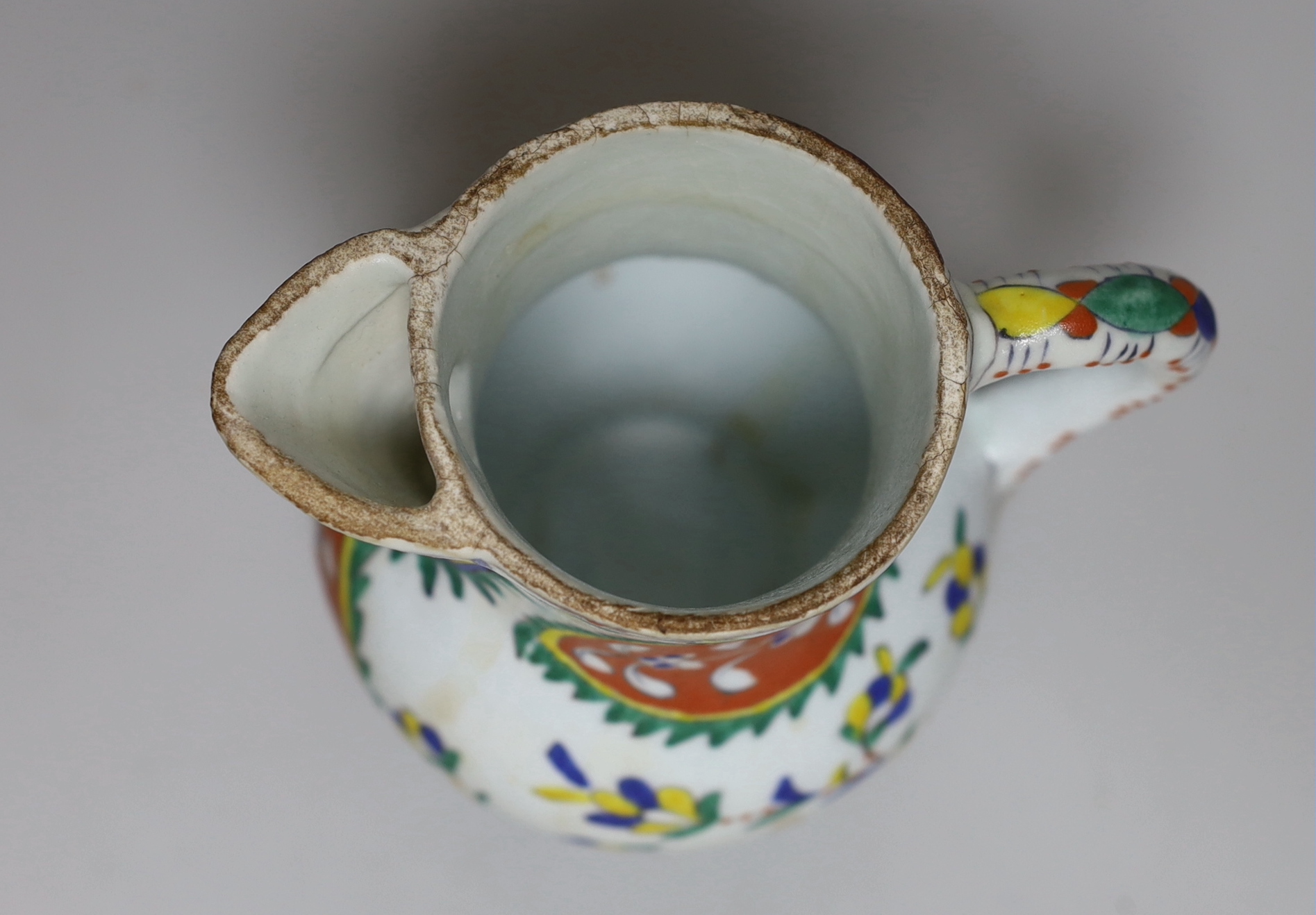 Turkish Kutahya pottery jug hand painted with stylised flowers, 12.5cm high